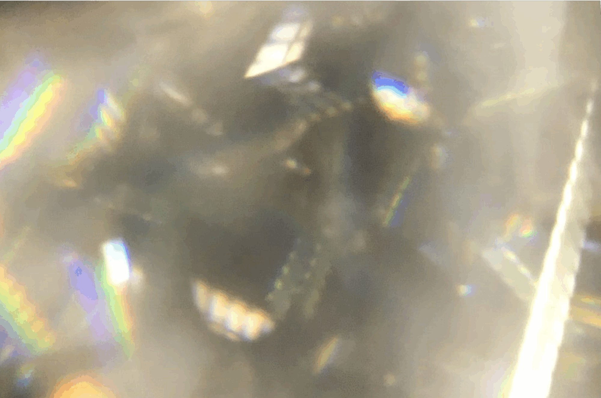 Heel sterke close-up van een diamant waarop de regenboog reflectie zichtbaar is.